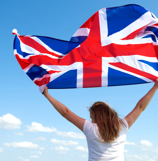 rear-view-young-woman-waving-british-flag